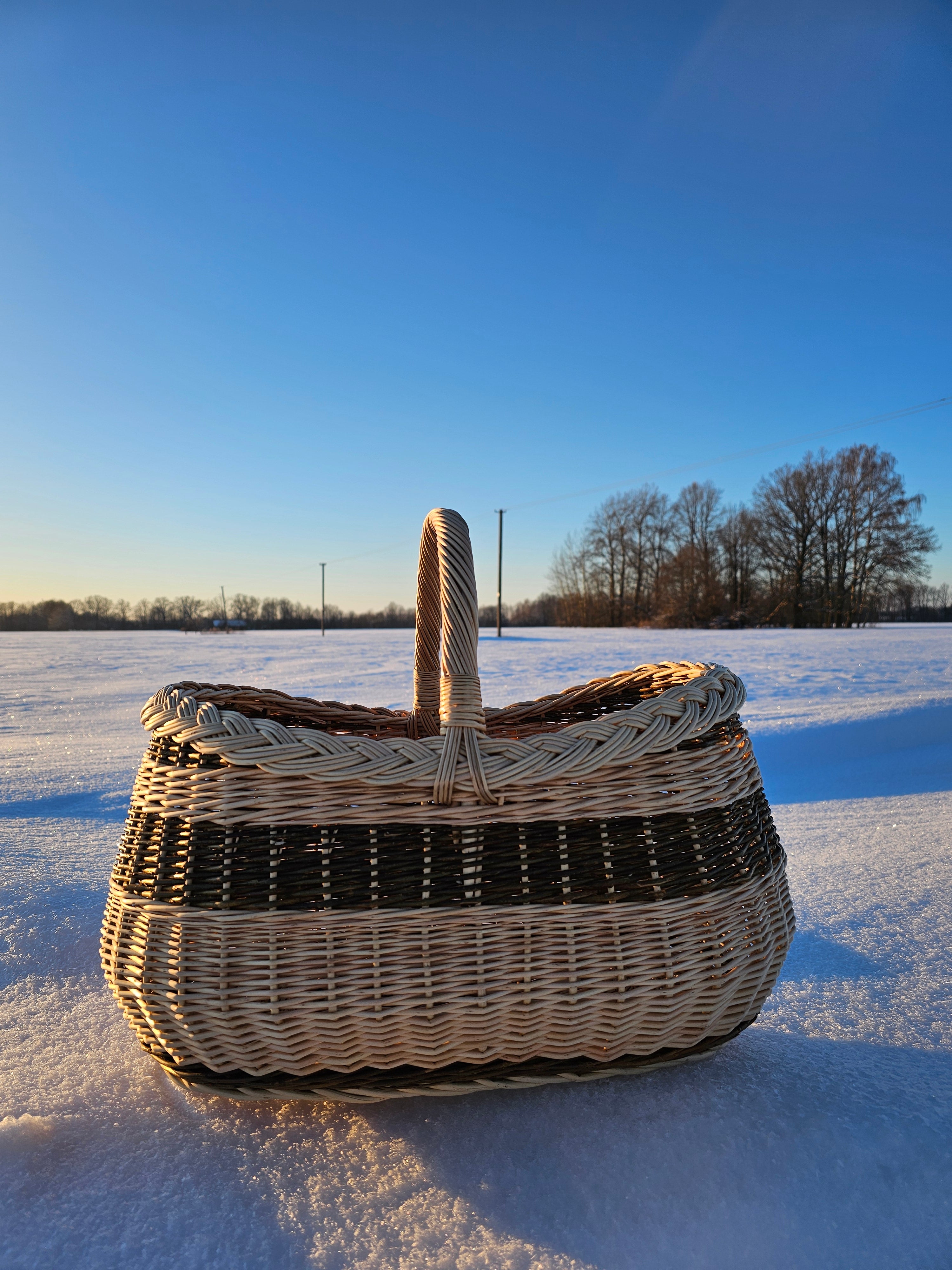 Wicker basket on a snowy landscape with clear blue sky